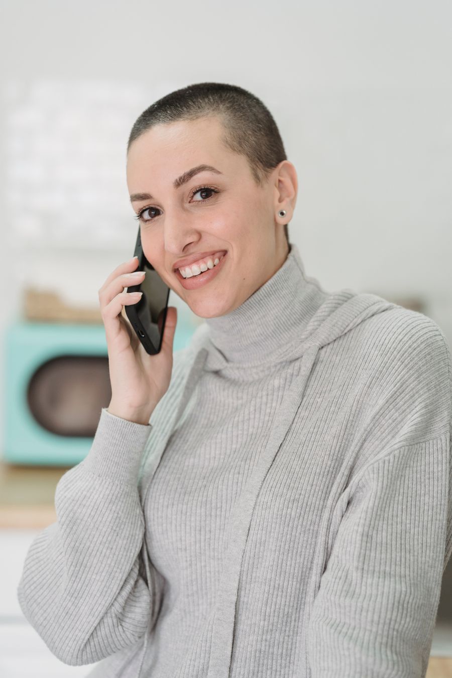 Nasmejana ženska govori po telefonu v slovenščini